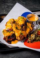 Grilled Peri Peri Chicken with Creamy Sauce and Crispy Garnish served in tray isolated on grey background closeup side view of A la carte Food platter photo