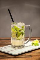 Refreshing Classic Mojito Soda with Lime and Mint served in mug isolated on wooden table side view of cold beverages drink photo