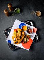 Grilled Peri Peri Chicken with Creamy Sauce and Crispy Garnish served in tray isolated on grey background top view of A la carte Food platter photo