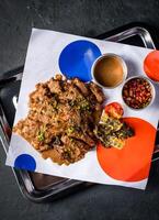 Spicy Grilled Jerk Chicken Slice with Sweet and Sour Sauce served in tray isolated on grey background closeup top view of A la carte Food platter photo