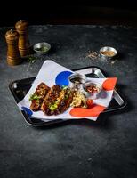 Hickory Bbq Beef Brisket Belly with Dipping Sauces and green onion served in tray isolated on grey background side view of A la carte Food platter photo