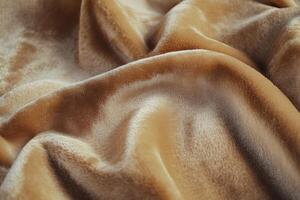 Soft golden fabric draped elegantly on a flat surface, enhancing texture and warmth photo