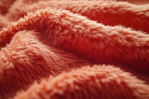 Soft, fluffy fabric in warm orange tones resting on a surface with natural light illuminating it photo
