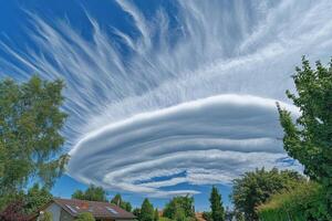 Striking spiral cloud formation over suburban neighborhood showcasing stunning colors in the afternoon sky photo