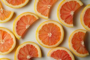 Sliced pink grapefruit arranged beautifully on a white background in natural light photo