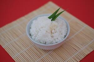 Cooked rice in a bowl with red background photo