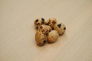 Quail eggs on a wooden table. Close-up, selective focus. photo