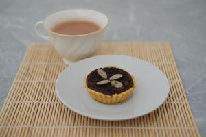 Chocolate tart with almond on white plate. Selective focus. photo