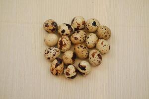 Quail eggs on a wooden background. Close-up, selective focus. photo