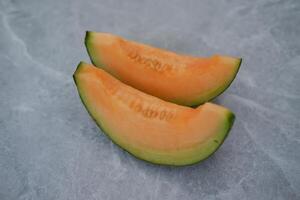 Sliced cantaloupe melon on a marble background photo
