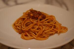 Spaghetti bolognese on a white plate in a restaurant photo