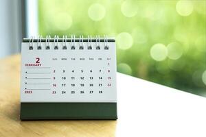 Calendar page February of the year 2025 white color on table. with copy space and business design. concept of planning and setting new strategic goals. photo