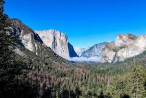 Misty Valley Surrounded by Majestic Mountain Peaks photo