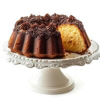 A Bundt cake and a slice on a cake platter, isolated on a white background. photo