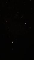 A black sky with snow falling from the sky video