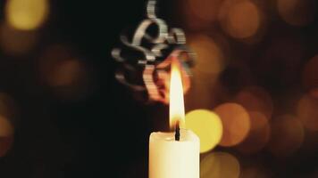 A candle is lit in front of a bokeh background video