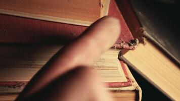 A person's finger is touching a stack of books video