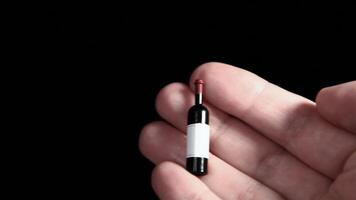 A person holding a small bottle with a red cap video