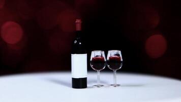 A bottle of red wine and two glasses on a table video