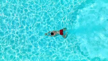 Aerial view as a man dives into the pool and swims. video