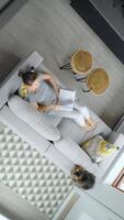 Overhead view of woman reading the book, lying on couch at home video