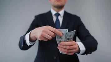 Formally dressed man carelessly throws US Dollar bills towards the camera video