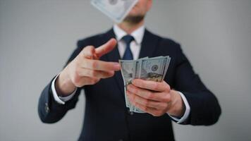 Formally dressed man carelessly throws US Dollar bills towards the camera video