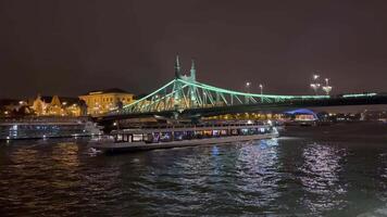 A boat is traveling under a bridge at night video