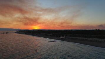 épico pôr do sol Visão rio fusão para dentro a mar com montanhas dentro a fundo video