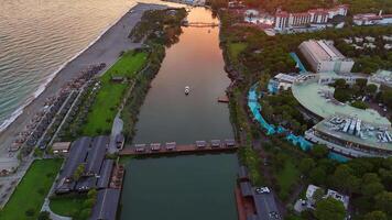 ponte levadiça sobre rio encontro a mar às pôr do sol, lancha passagem de video
