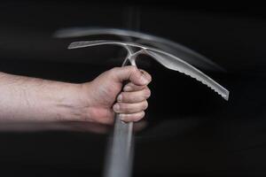 Close up of man's hand holding a climbing ice axe with motion effect photo