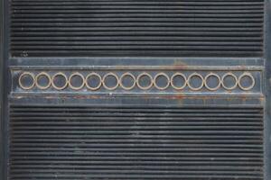 A part of an old and rusted door with a metal surface photo