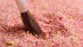 The colored granules are slowly stirred with a brush. asm . Relaxing . video