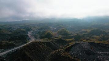 4k aerial footage of a barren area in a volcanic area with winding roads surrounded by piles of rocks and sand left over from the fall of volcanic material during an eruption. video