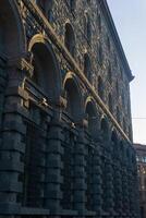 architectural background, dark facade of an old city building, barely illuminated by the morning sun rays photo