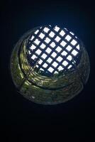 view from the dungeon upwards through a hatch covered with a grate photo