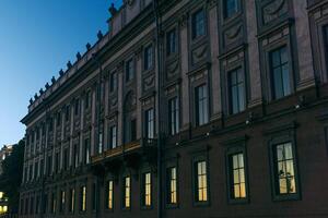 architectural background, dark facade of an old city building, barely illuminated by the morning sun rays photo