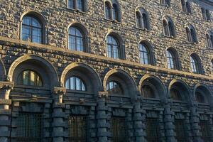 architectural background, dark facade of an old city building, barely illuminated by the morning sun rays photo