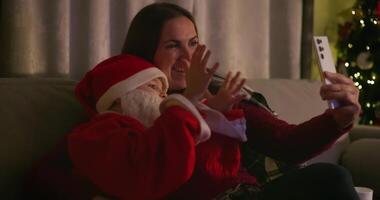 Mother and child in Santa outfit taking selfie video