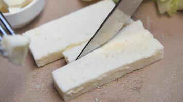 Slicing Fresh Cheese Using a Fork and Knife to Create Delicious Appetizers and Meals video
