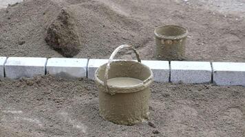 Construction Site Buckets, Sand, and Paved Blocks for Ongoing Work and Development video