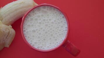glass of milk and banana on table at morning video