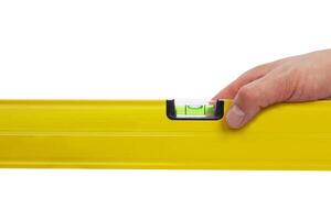 Hand holding yellow level tool isolated on white background photo