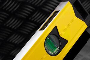 Close-up of yellow level tool on textured surface photo