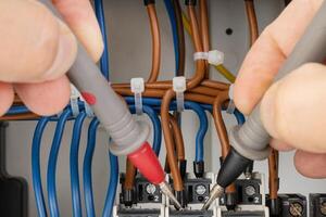 Testing electrical circuits with probes in a panel photo