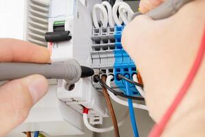 Testing electrical connections in terminal block panel photo