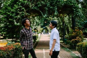 Two Southeast Asian men engaged in a lively conversation at a city square. photo