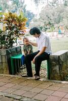 A father and his child sitting and chatting in a city square photo