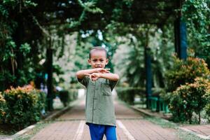 A young Southeast Asian child showing the number two with their fingers, symbolizing peace or victory photo