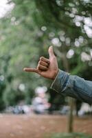 Thumb and pinky finger raised in a gesture, symbolizing connection and friendship photo